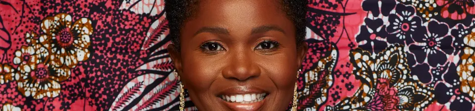 Fatoumata smiling against a colorful patterned backdrop